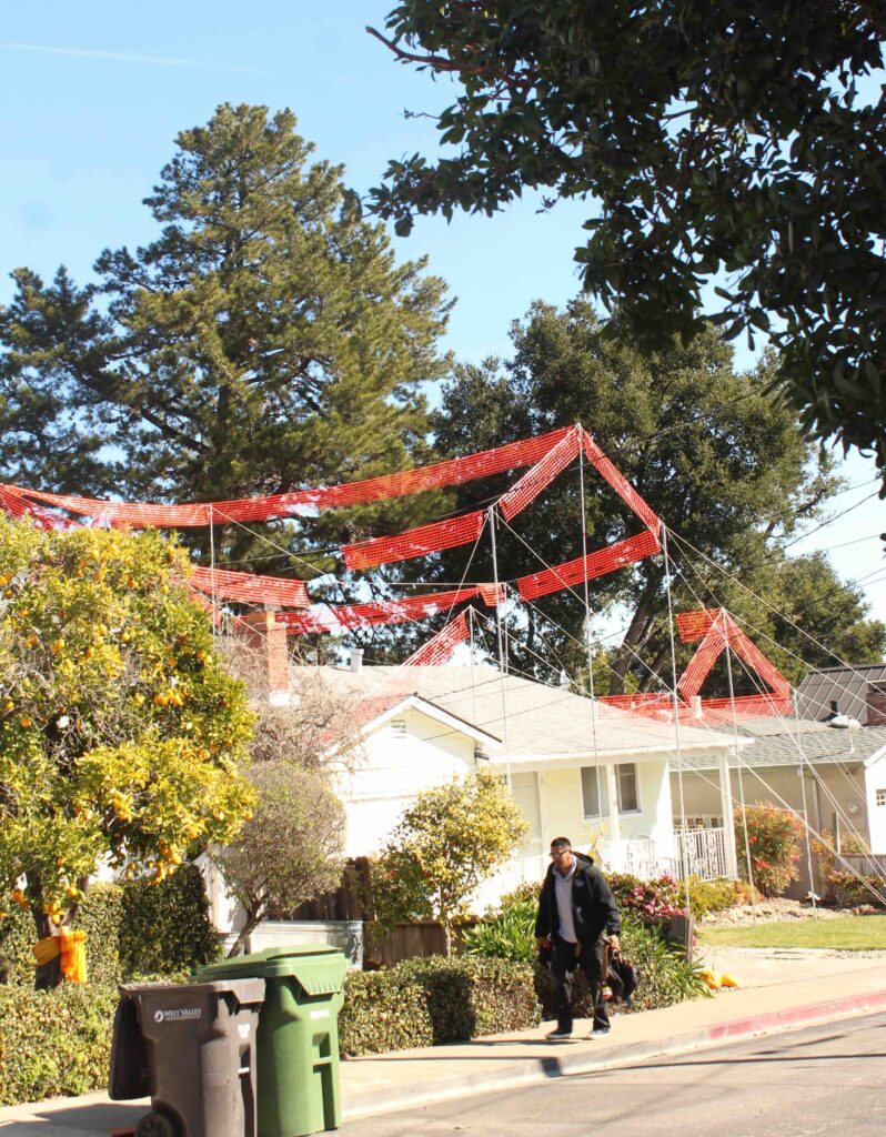 person walks by Los Gatos house with story poles