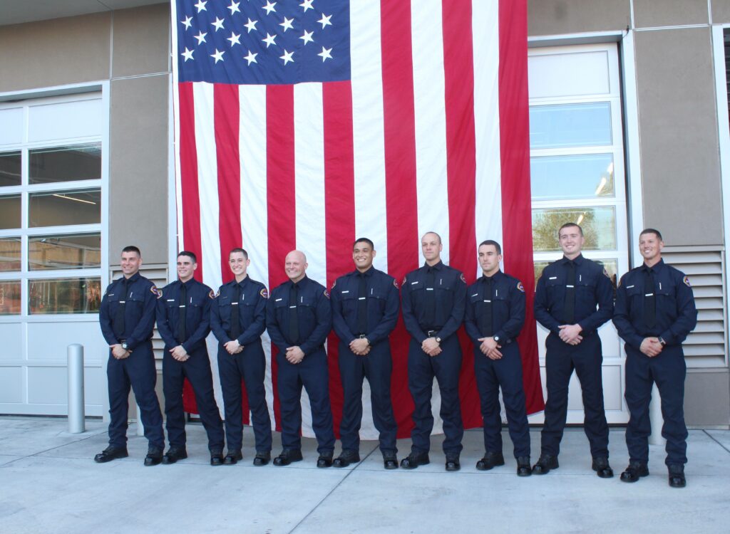 Brand new Santa Clara County Firefighters stand in front of American flag