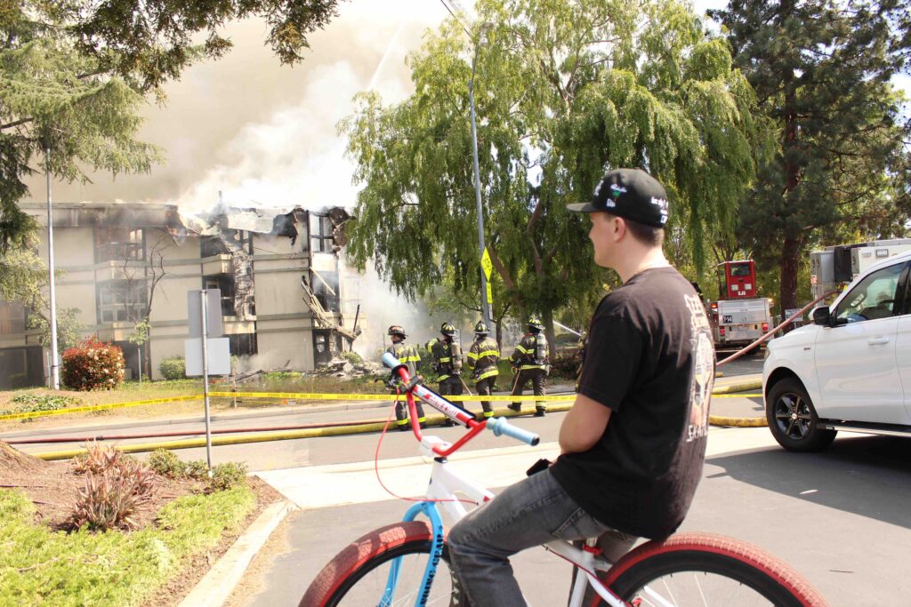 cyclists watches building burn