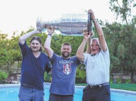 3 people hold Stanley Cup