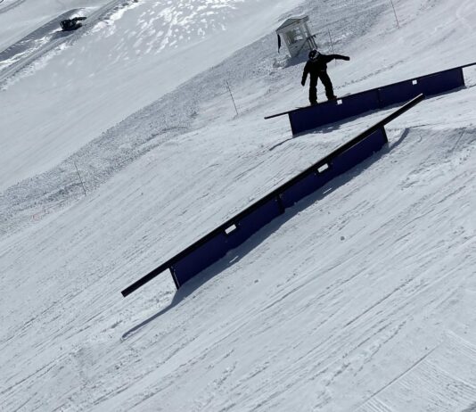 Snowboarder grinds a rail in the Sierras