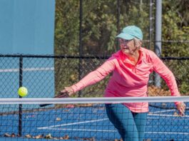 pickleball player strikes ball