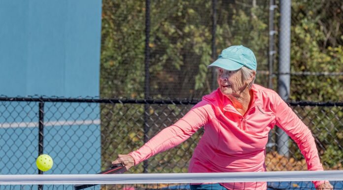 pickleball player strikes ball