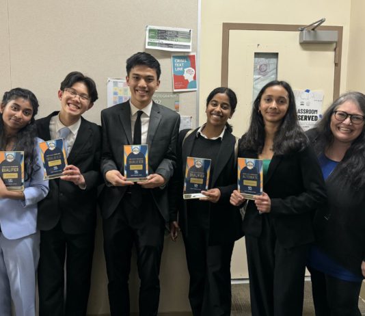 Debaters awarded for rhetorical skills debate team with trophies