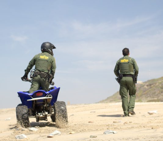 US Customs and Border Patrol agents on sand