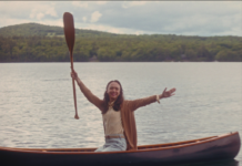 canoe with woman holding up a paddle