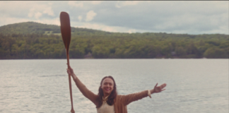 canoe with woman holding up a paddle