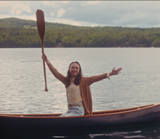 canoe with woman holding up a paddle