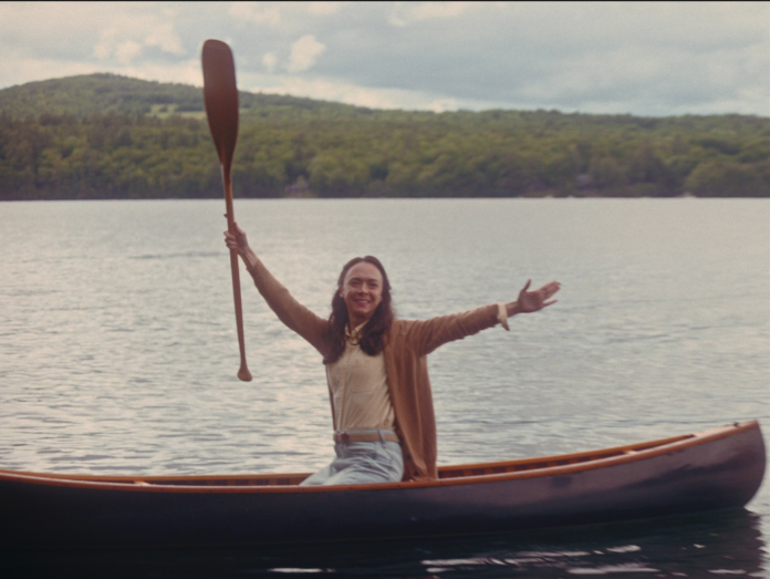 canoe with woman holding up a paddle