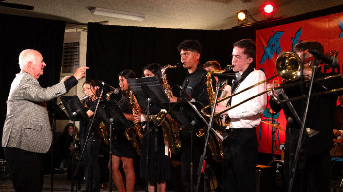 Older man conducting a group of younger musicians