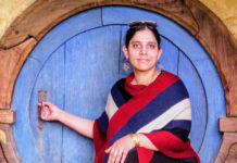 Photo of a woman in front of a round blue door