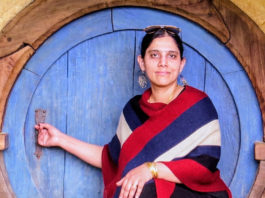 Photo of a woman in front of a round blue door