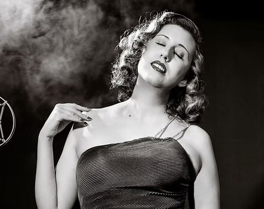 The Sweetheart of Swing at Jazz on the Plazz Black-and-white photo of woman in an evening gown by an old-fashioned microphone