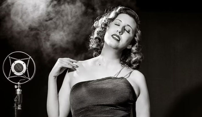 Heidi Evelyn Black-and-white photo of woman in an evening gown by an old-fashioned microphone