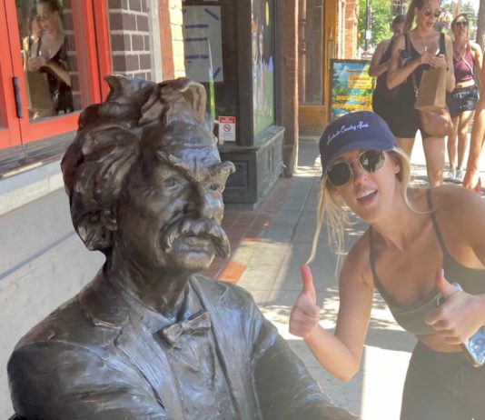 Mark Twain statue with woman giving a thumbs-up