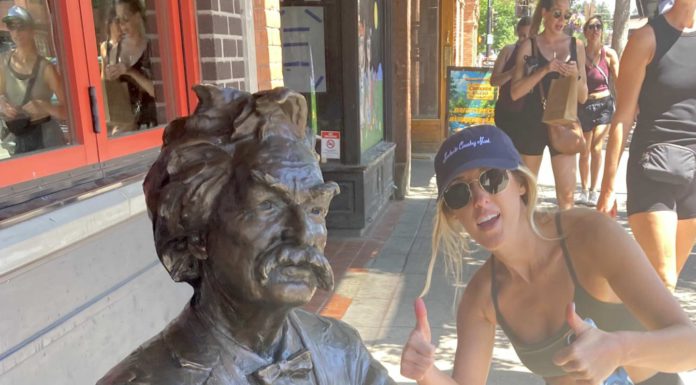 Mark Twain statue with woman giving a thumbs-up