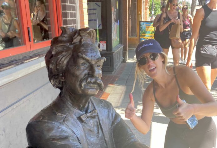 Mark Twain statue with woman giving a thumbs-up