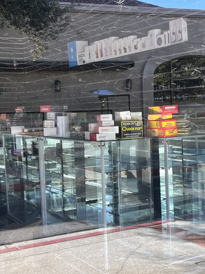mirrored display case with fake urine and other smoke shop-style items
