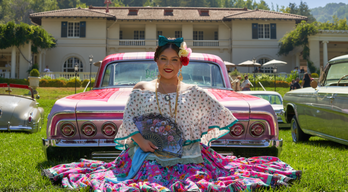 3rd Annual Lowrider Art Showcase happening this weekend in Saratoga woman in pink dress on lawn in front of a car