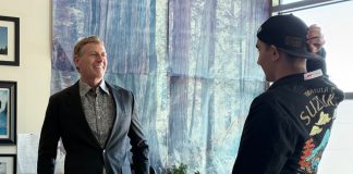 educator named grand marshal of parade speaks with student