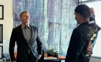 educator named grand marshal of parade speaks with student