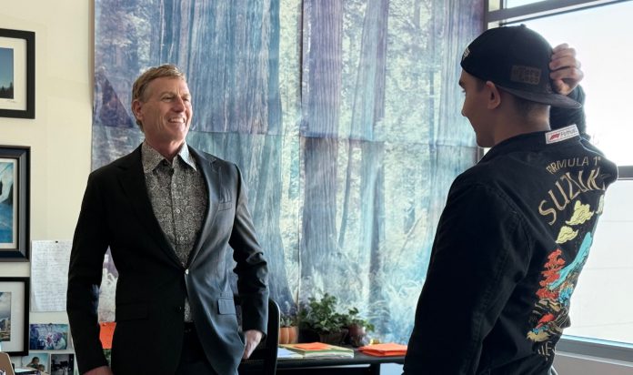 educator named grand marshal of parade speaks with student