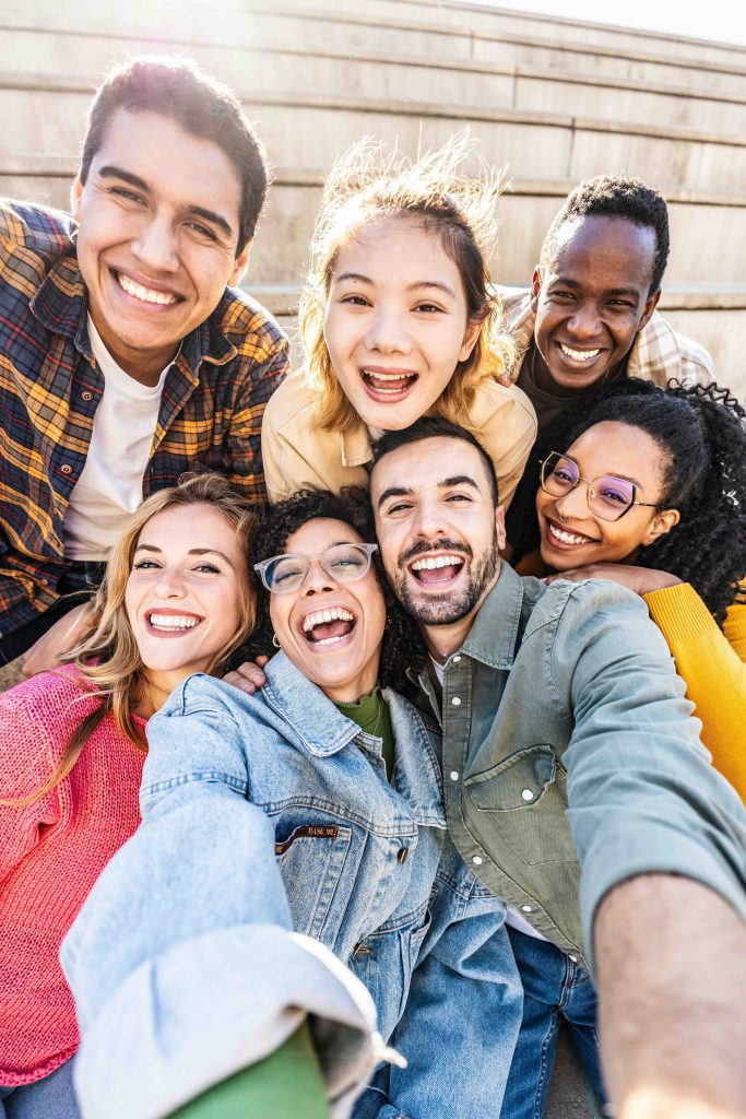 Group of young people smiling at camera outside