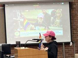 Amid strident disagreement, Los Gatos votes to move forward with Pride Flag plan woman with rainbow flag during public comment in Los Gatos