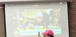 woman with rainbow flag during public comment in Los Gatos
