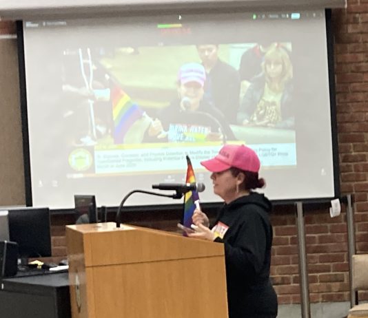 Amid strident disagreement, Los Gatos votes to move forward with Pride Flag plan woman with rainbow flag during public comment in Los Gatos