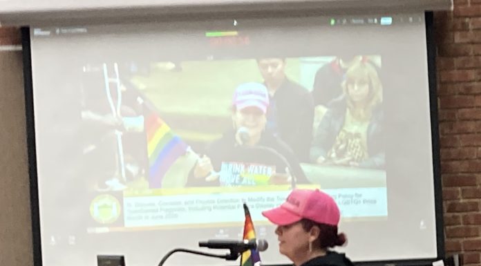 woman with rainbow flag during public comment in Los Gatos