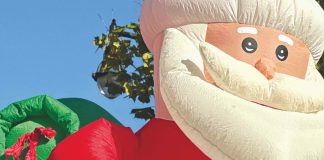 two kids on a float with an inflatable Santa behind them