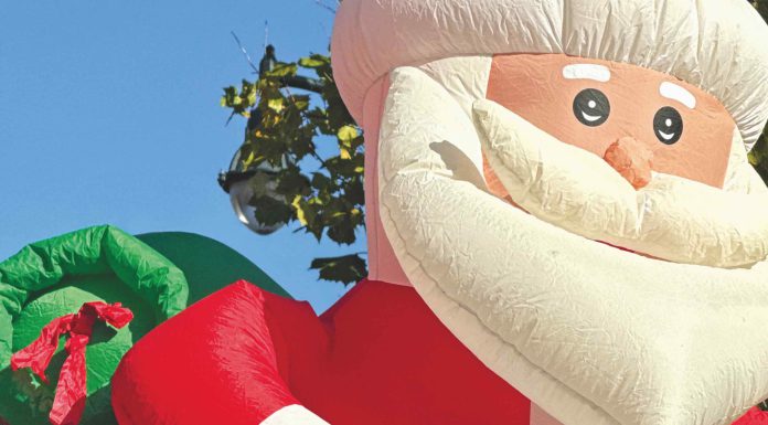 two kids on a float with an inflatable Santa behind them