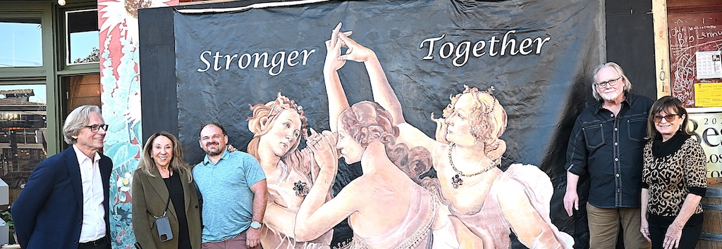 cafe family in front of the mural