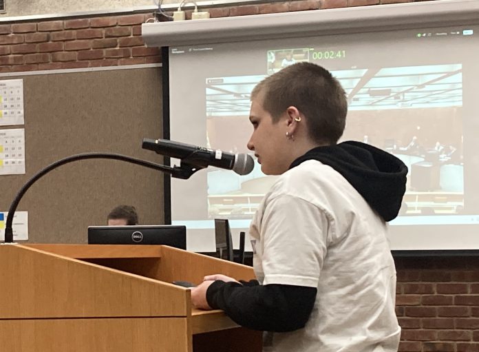 Lee Cummings high school student in a white shirt and short hair speaks