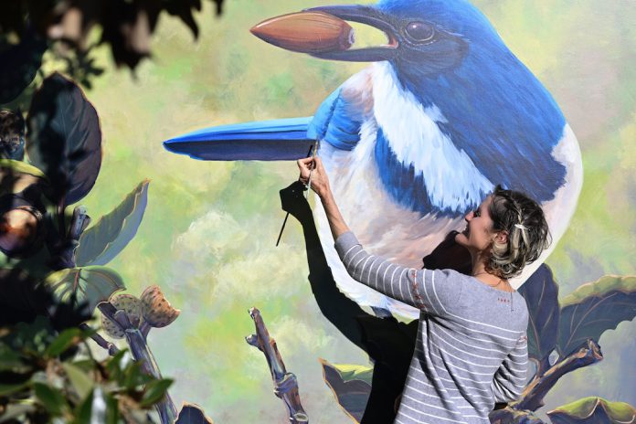 Morgan Bricca with bird mural at Whole Foods