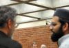 Town Attorney finds the initial conditions for mosque were discriminatory two commissioners speak at break while two Muslim attendees stand in the foreground