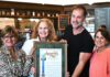 Gail Pellerin hands cafe an award